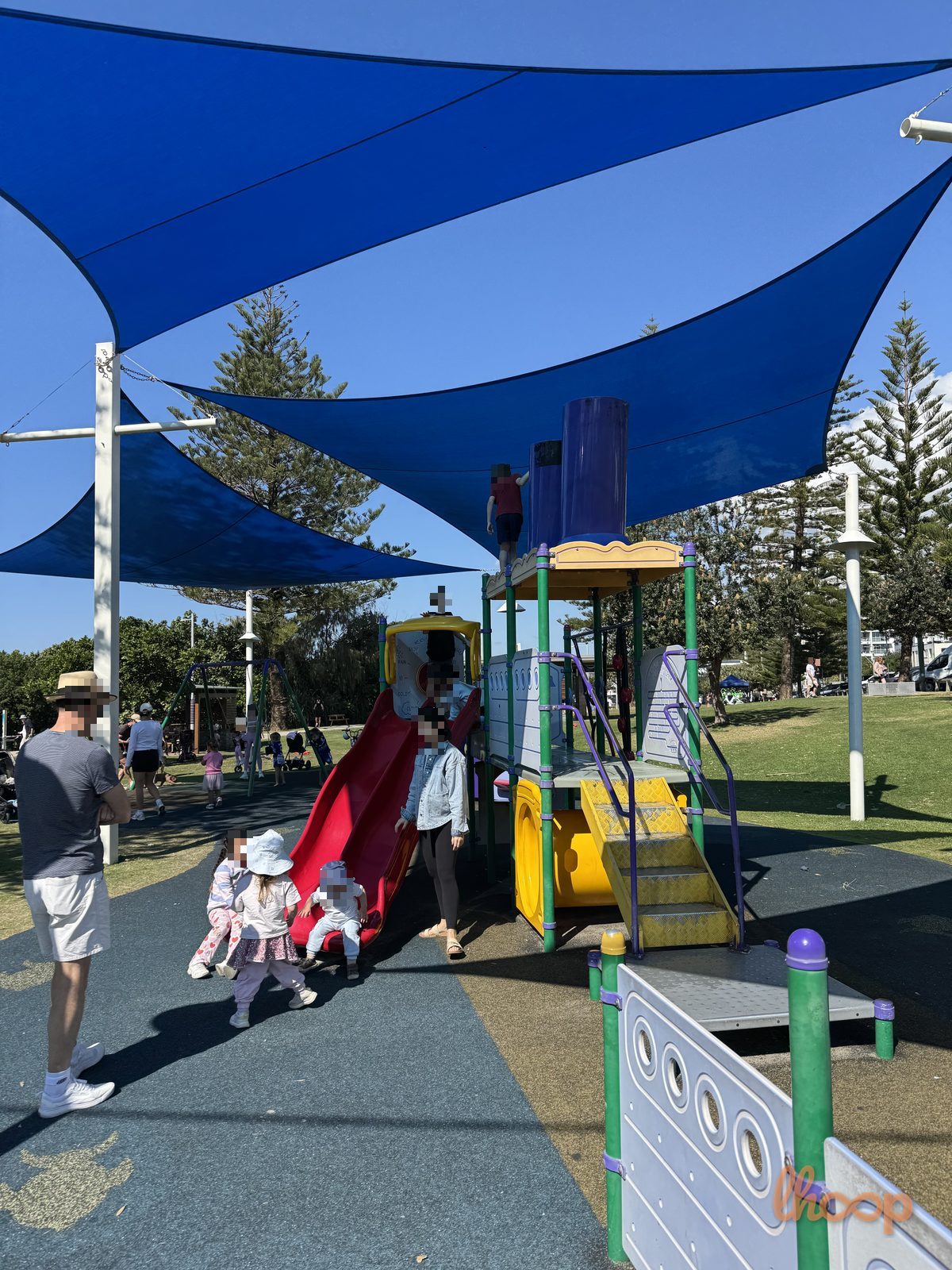 The main boat-themed tower with its red slide and blue funnels, under three big blue shade sails.
