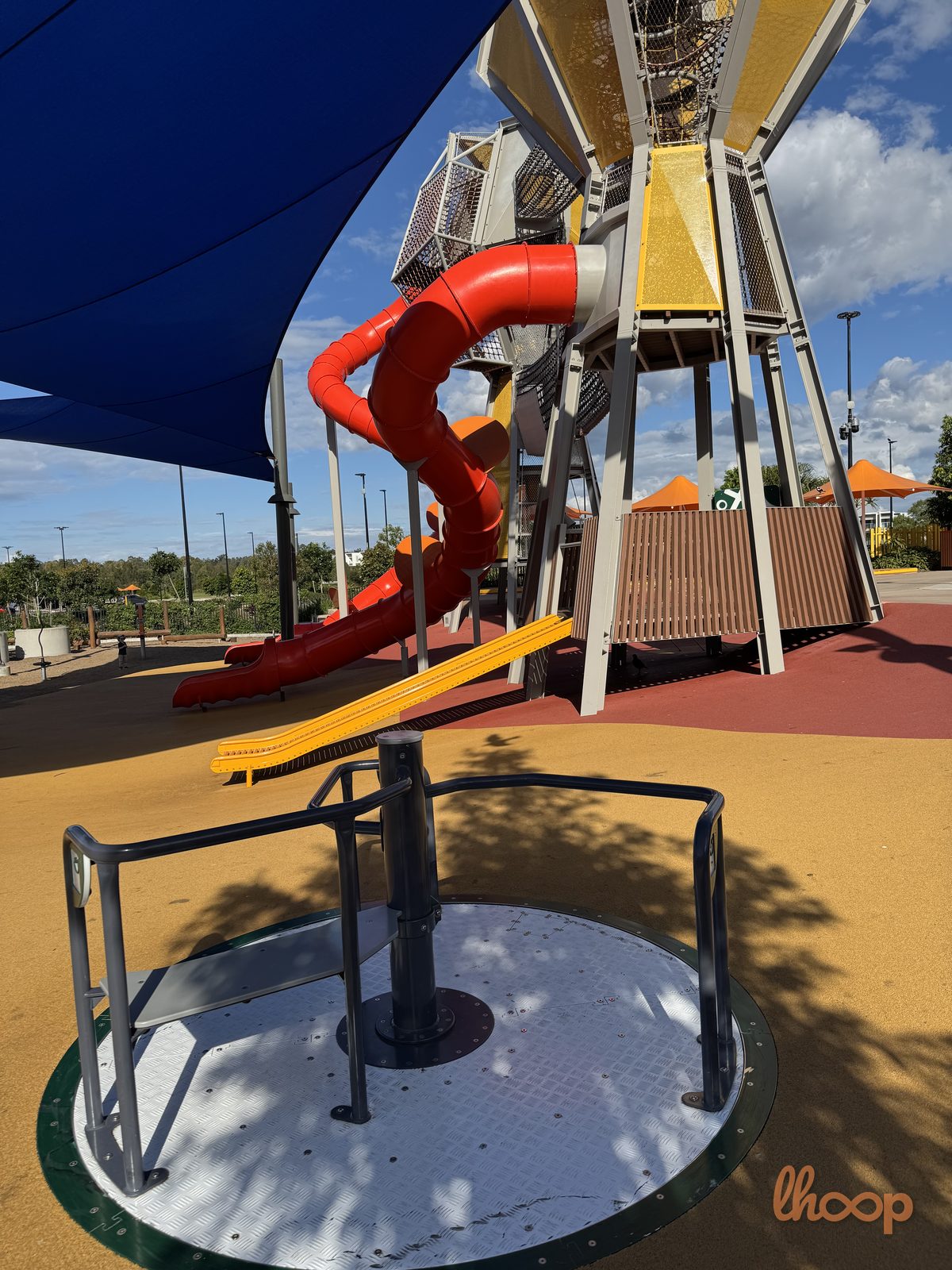 A play tower with a spinner and a red tube slide.